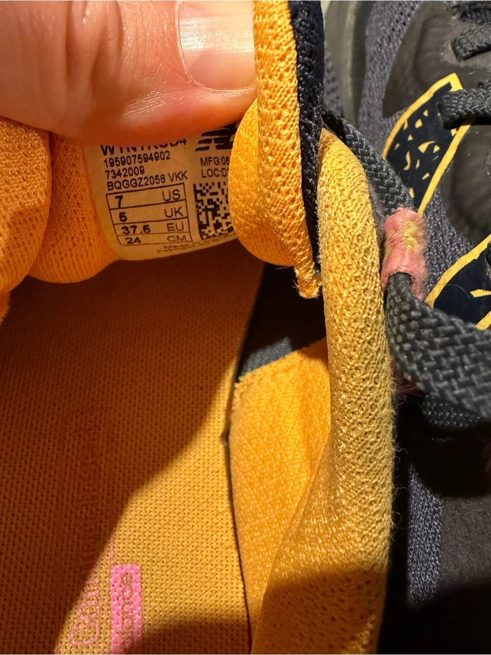 New Balance navy athletic sneakers with yellow and pink accents
